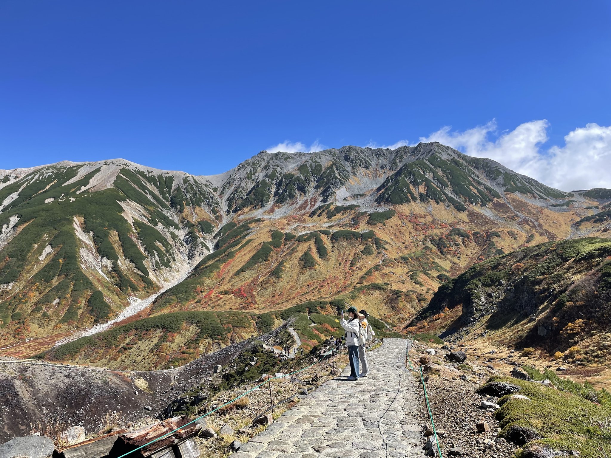 石畳の遊歩道と紅葉した岩山の谷