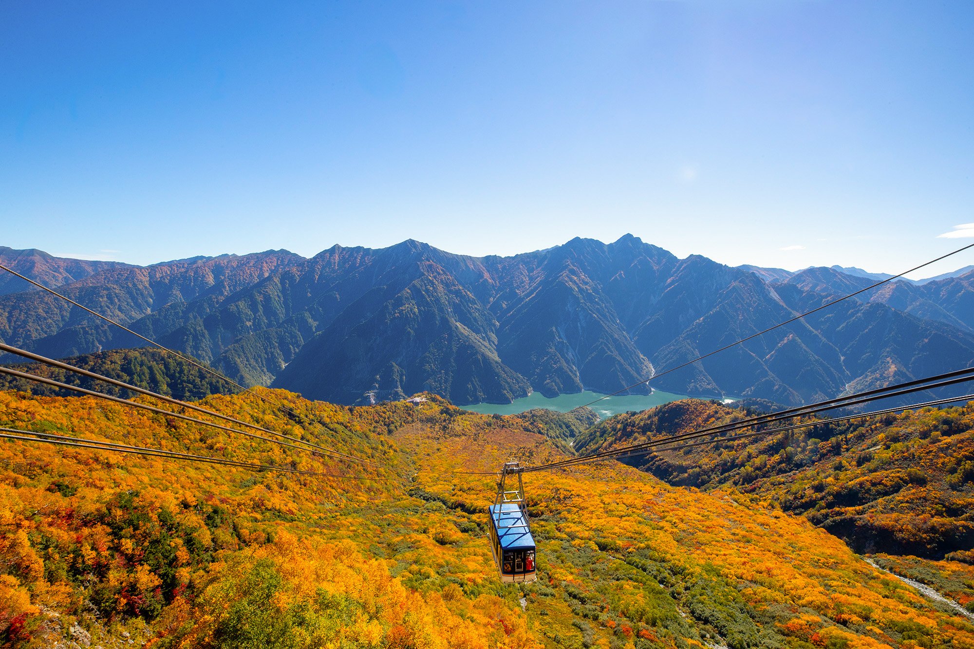黒部湖と黄葉した斜面を見下ろす立山ロープウェイ