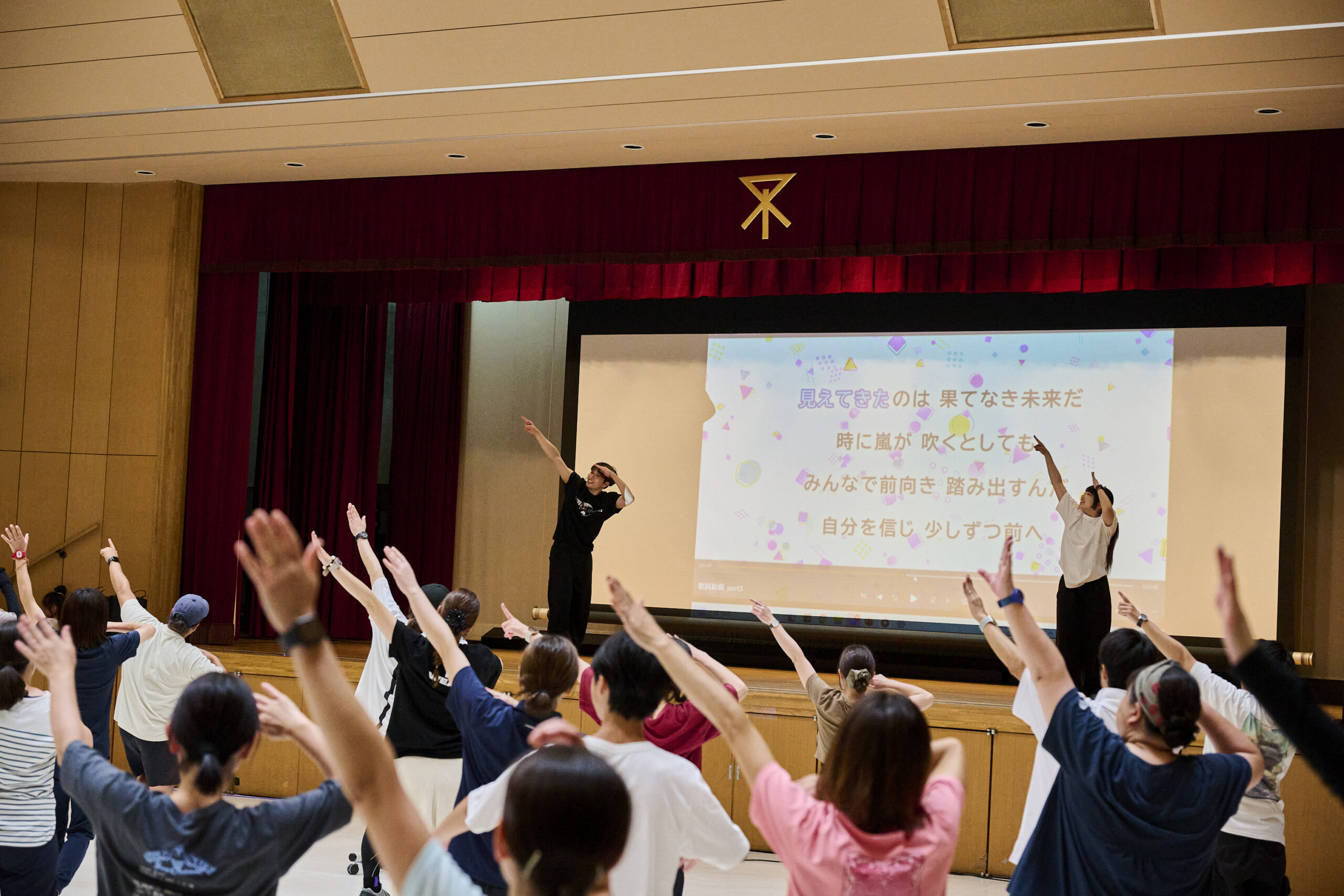 振付師と一緒に腕を動かす大阪市内小学校の教員