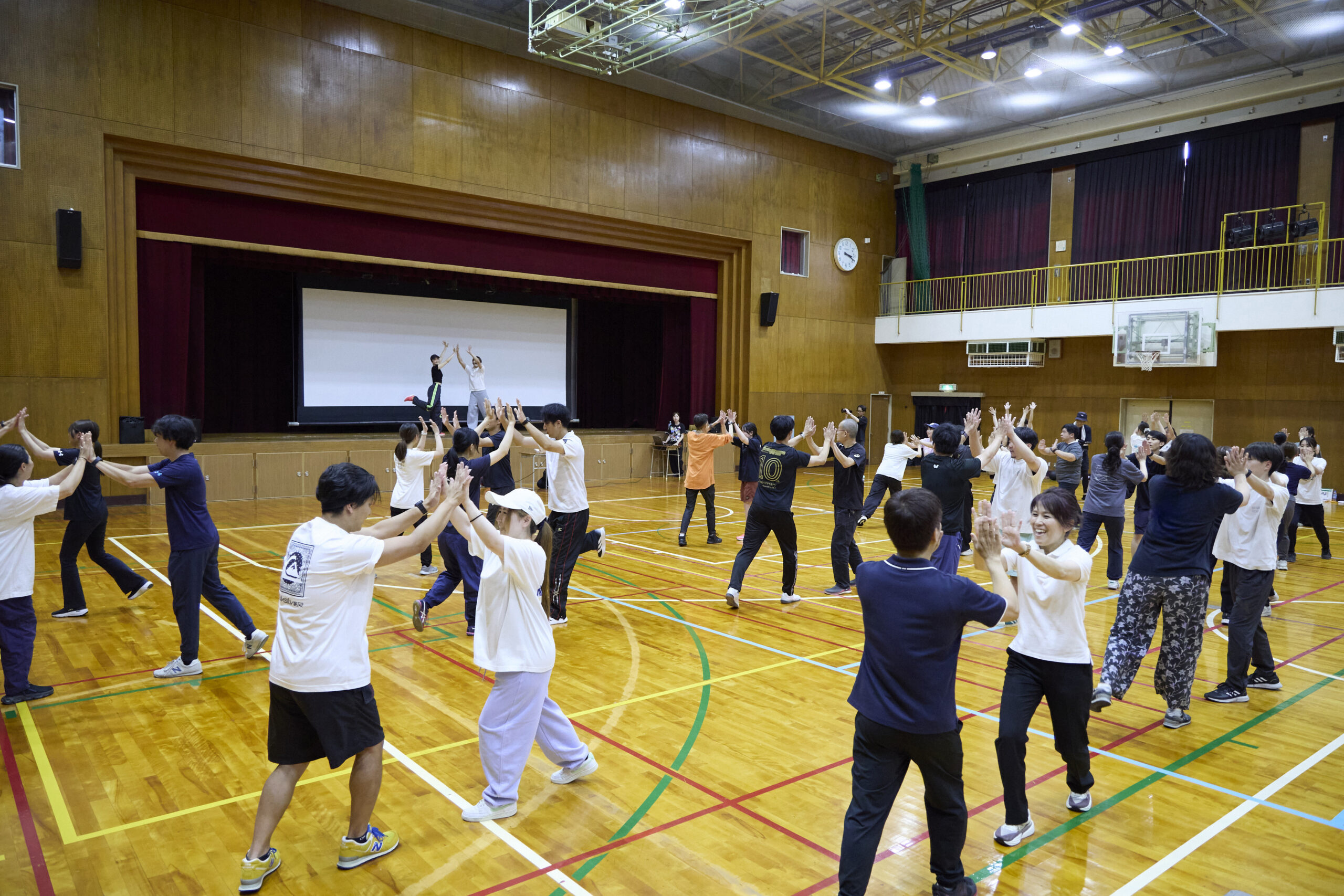 体育館全体を使ってダンスを学ぶ小学校教員