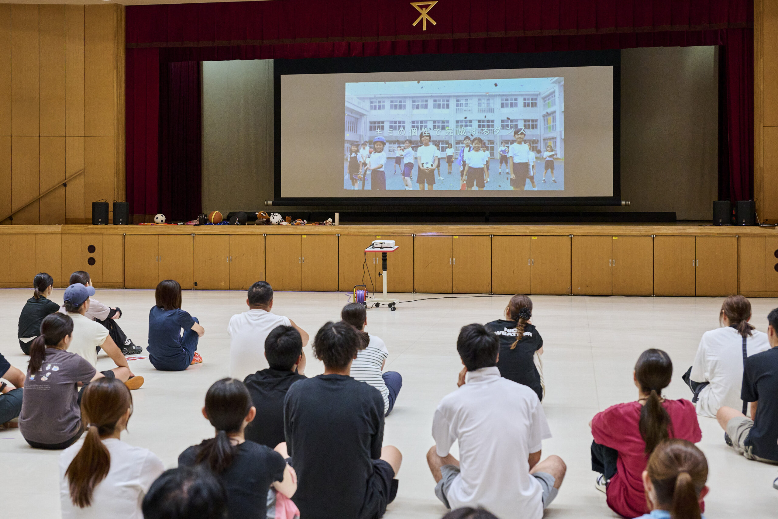 スクリーンを見ながら説明を聞く小学校教員