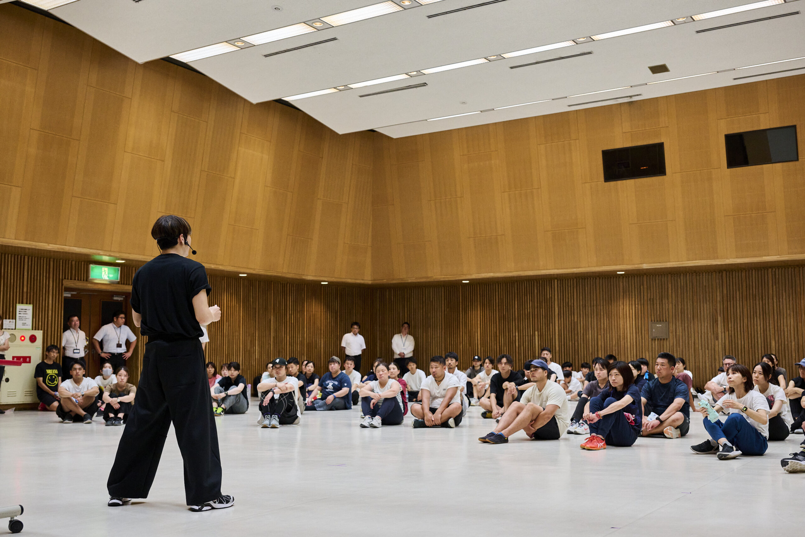 振付師の説明に耳を傾ける小学校教員