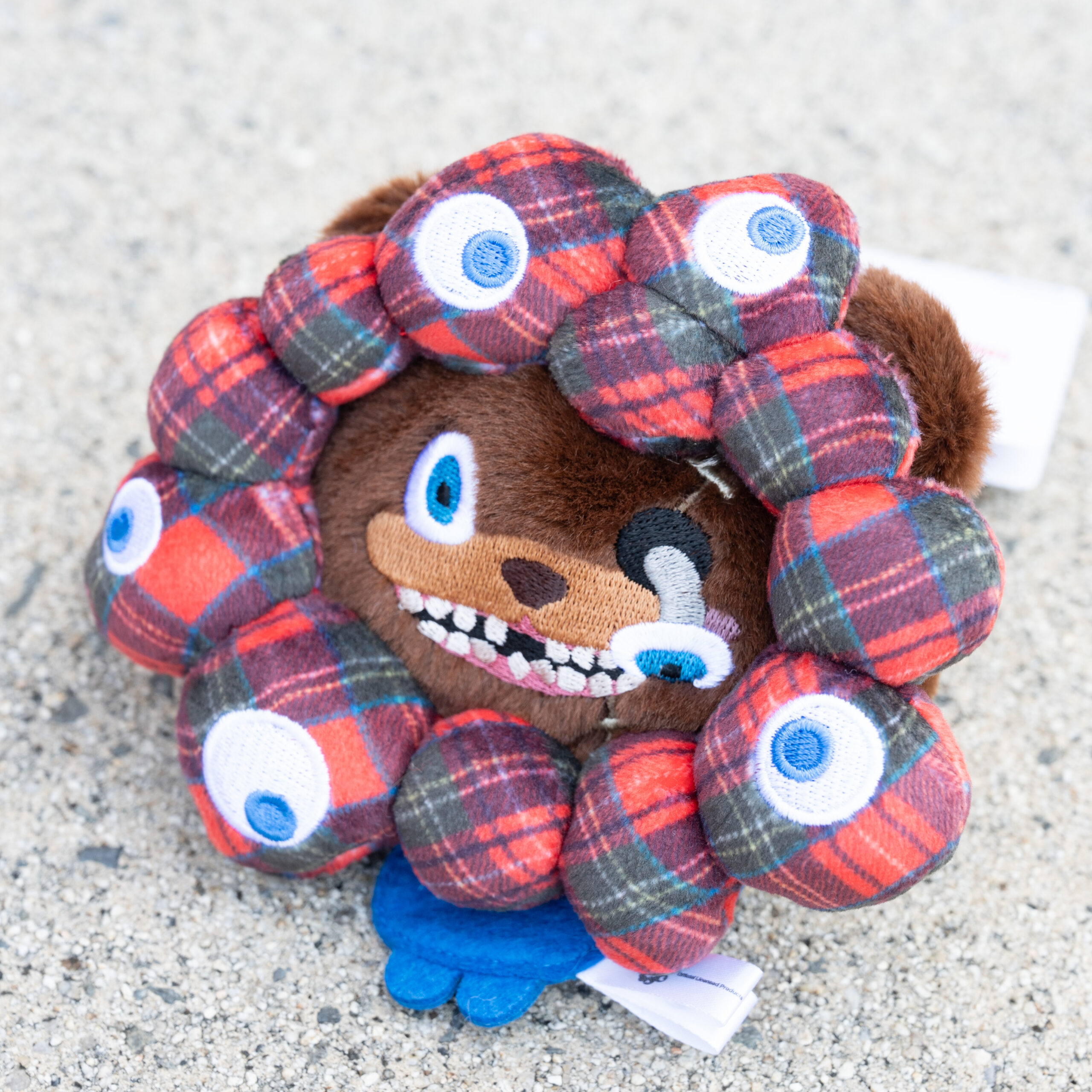 チェック柄のミャクミャクモチーフで顔を囲んだハミクマのマスコットキーチェーン