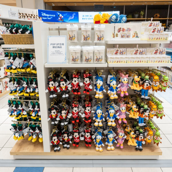 POP UP会場限定商品の案内と、ミッキー＆フレンズのぬいぐるみキーチェーンやシークレットストラップが並ぶ売り場