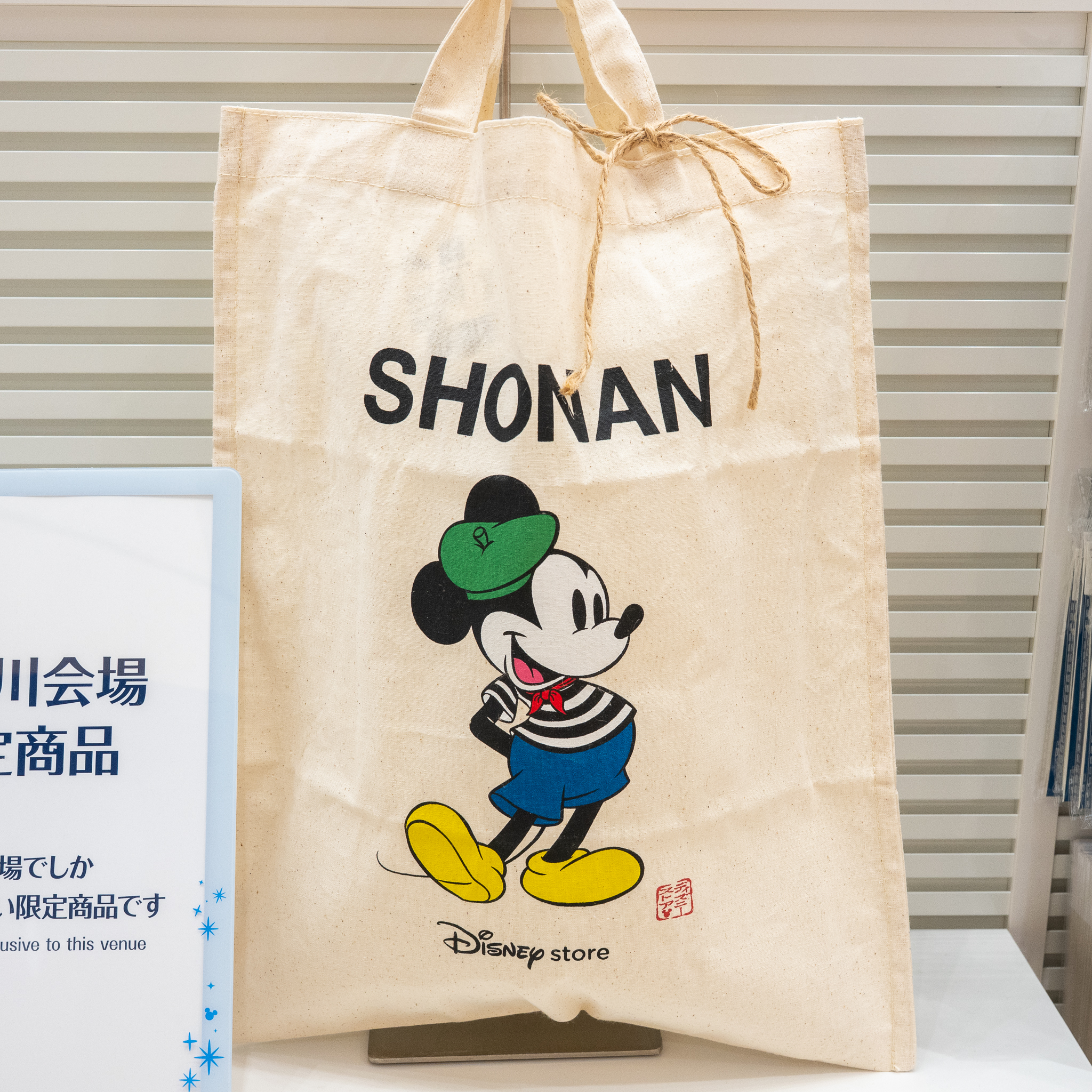 SHONANの文字と、グリーンの帽子にボーダーシャツのミッキーマウスが描かれたトートバッグ