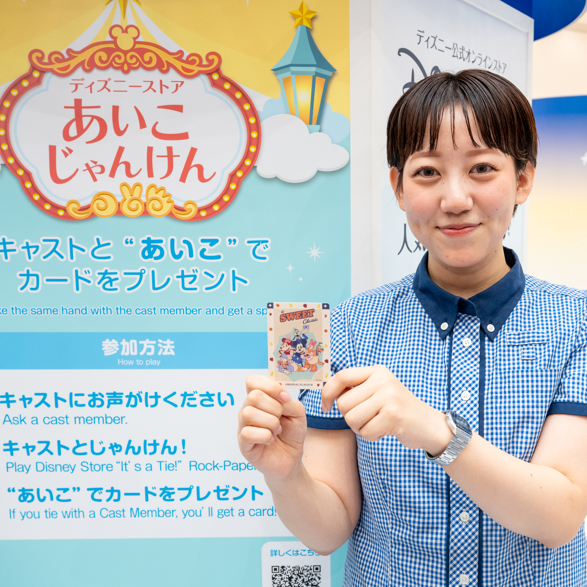 ディズニーストアあいこじゃんけんの案内の前で、カードを持つキャスト