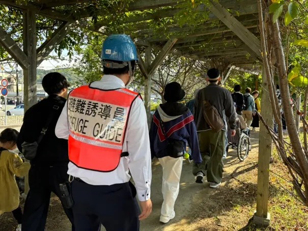 屋外通路を列になって避難する参加者