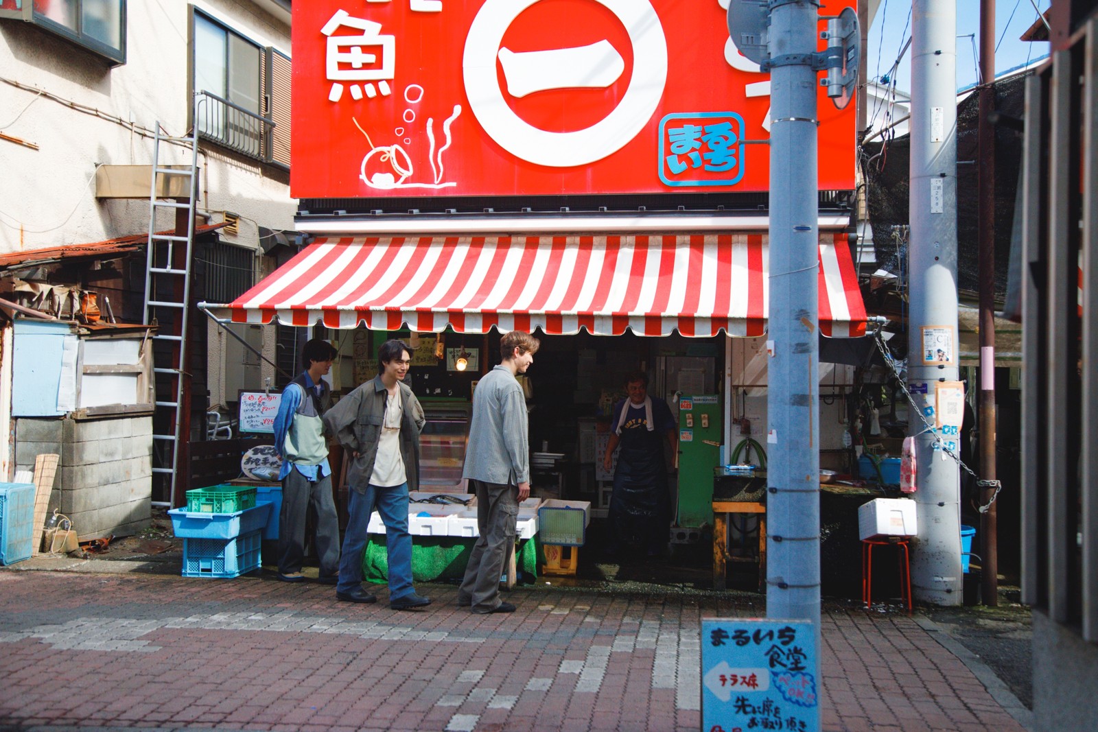 三崎の鮮魚店前に立つ3人
