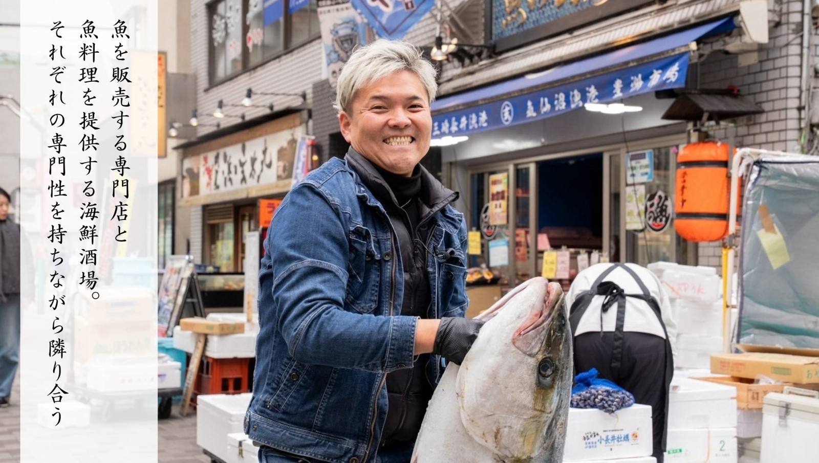 店先で大きな魚を持つ様子