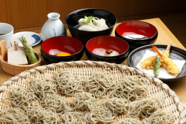 大ざるに盛られた新そばと薬味、海老天
