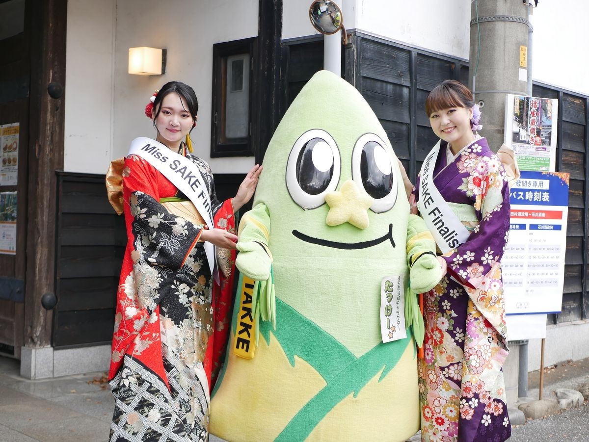 たっけーとMiss SAKEのたすきを着けた女性