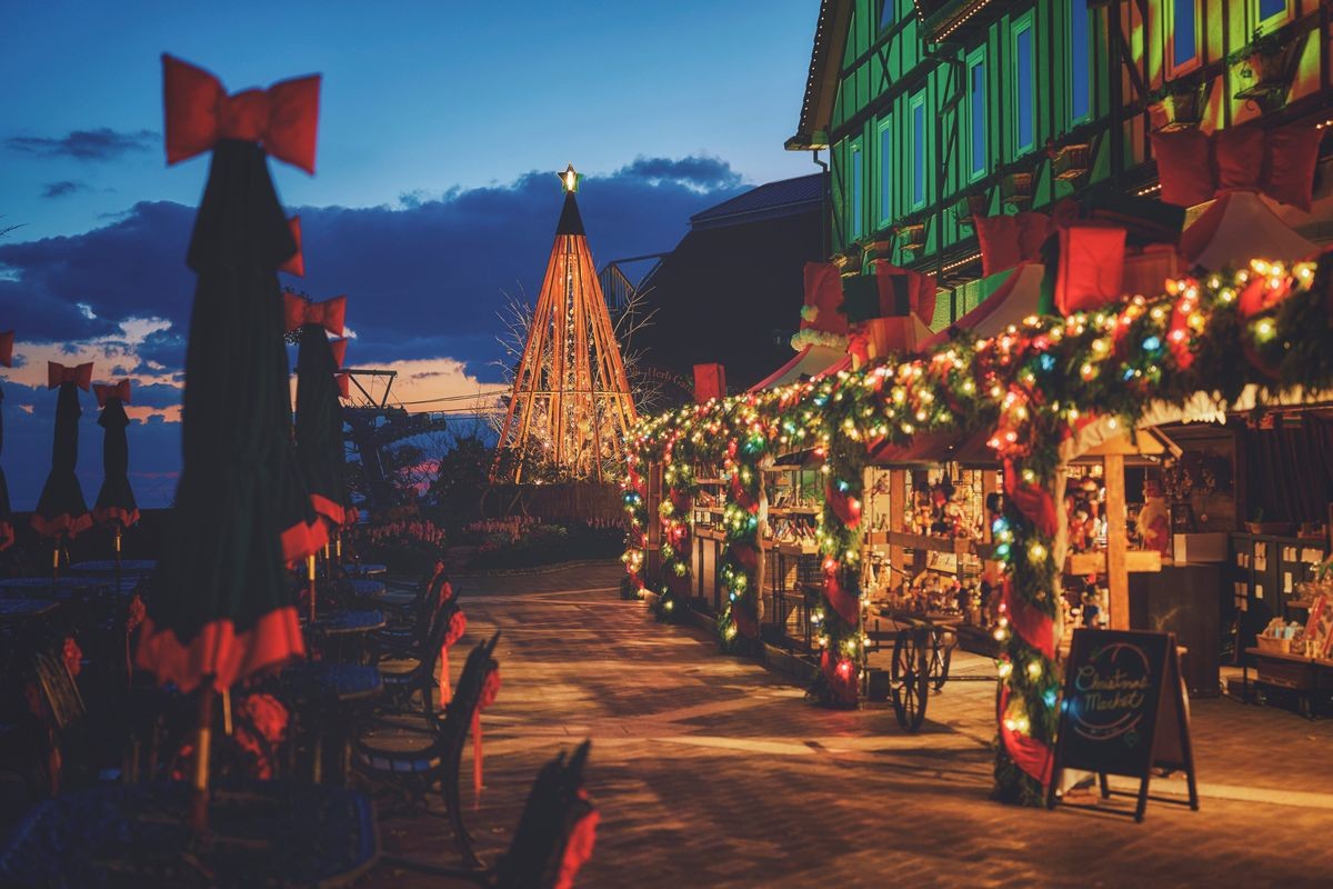 夕暮れの広場に並ぶクリスマスマーケットの屋台