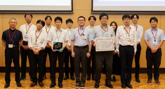 授賞式の盾と賞状を持つ日立ソリューションズ・テクノロジーの関係者