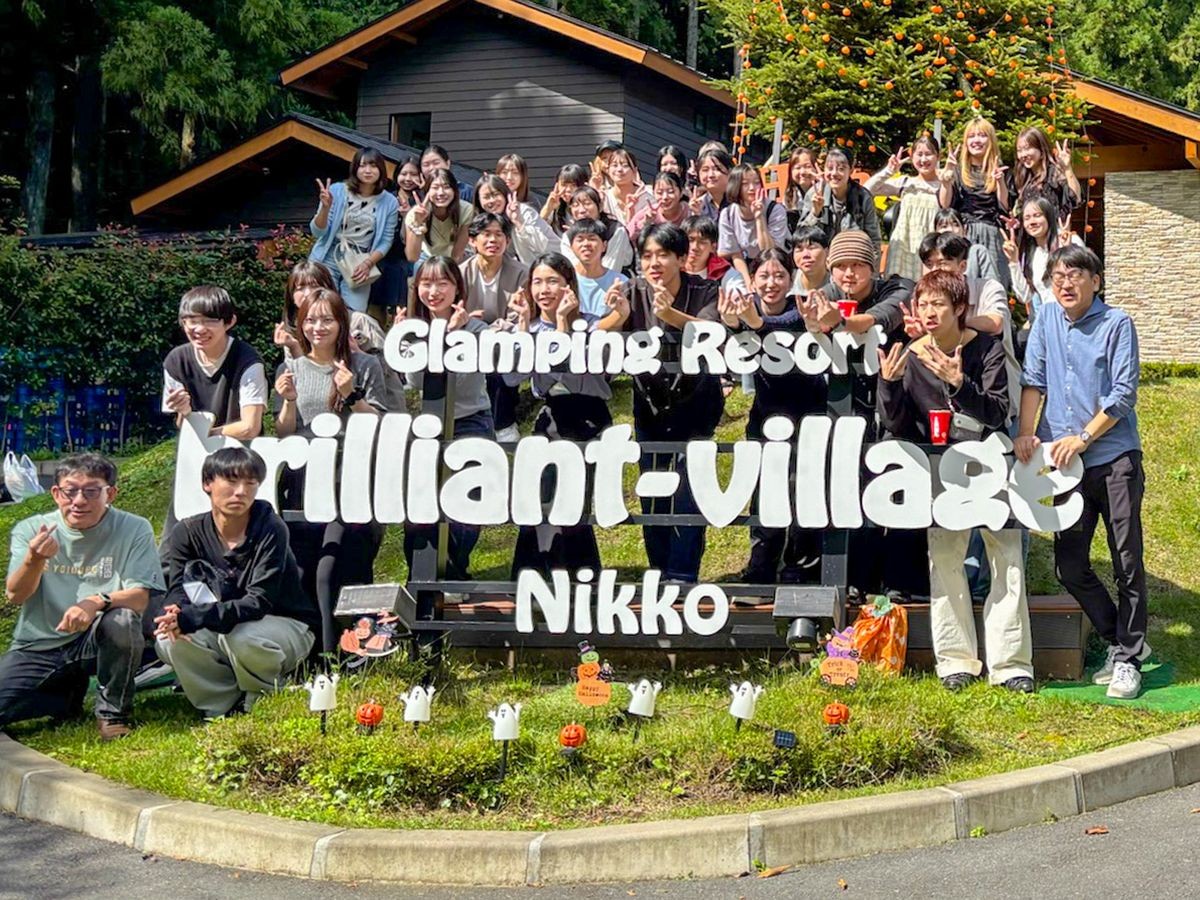 ブリリアントヴィレッジ日光の看板前の団体集合写真