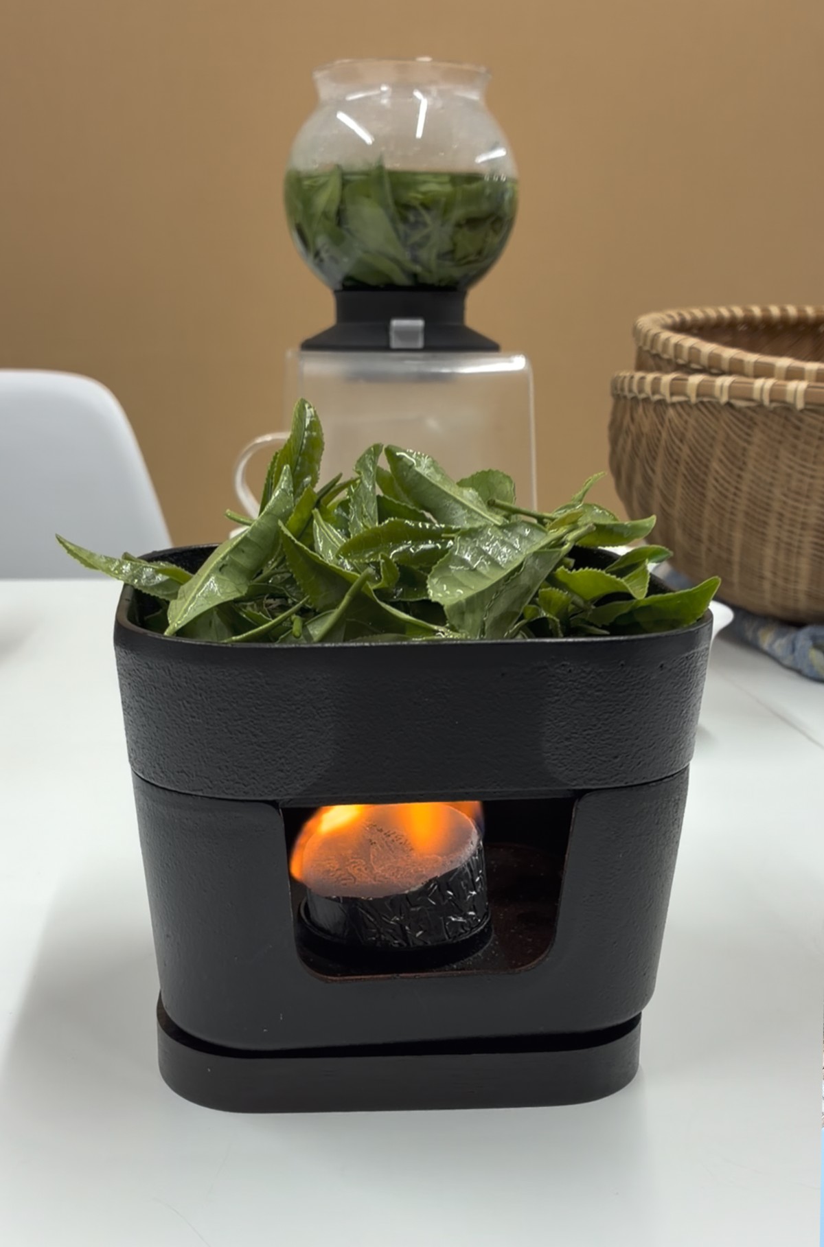 炎のある器具の上で加熱される茶葉
