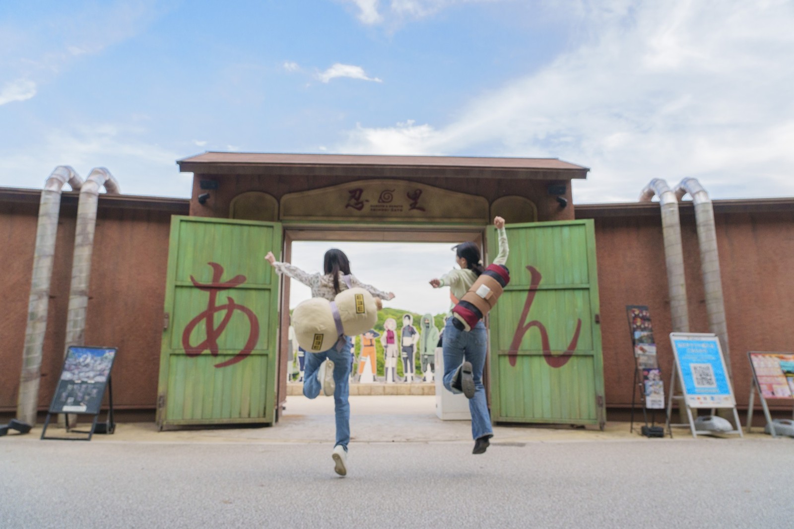 「忍里」の看板と緑色の門