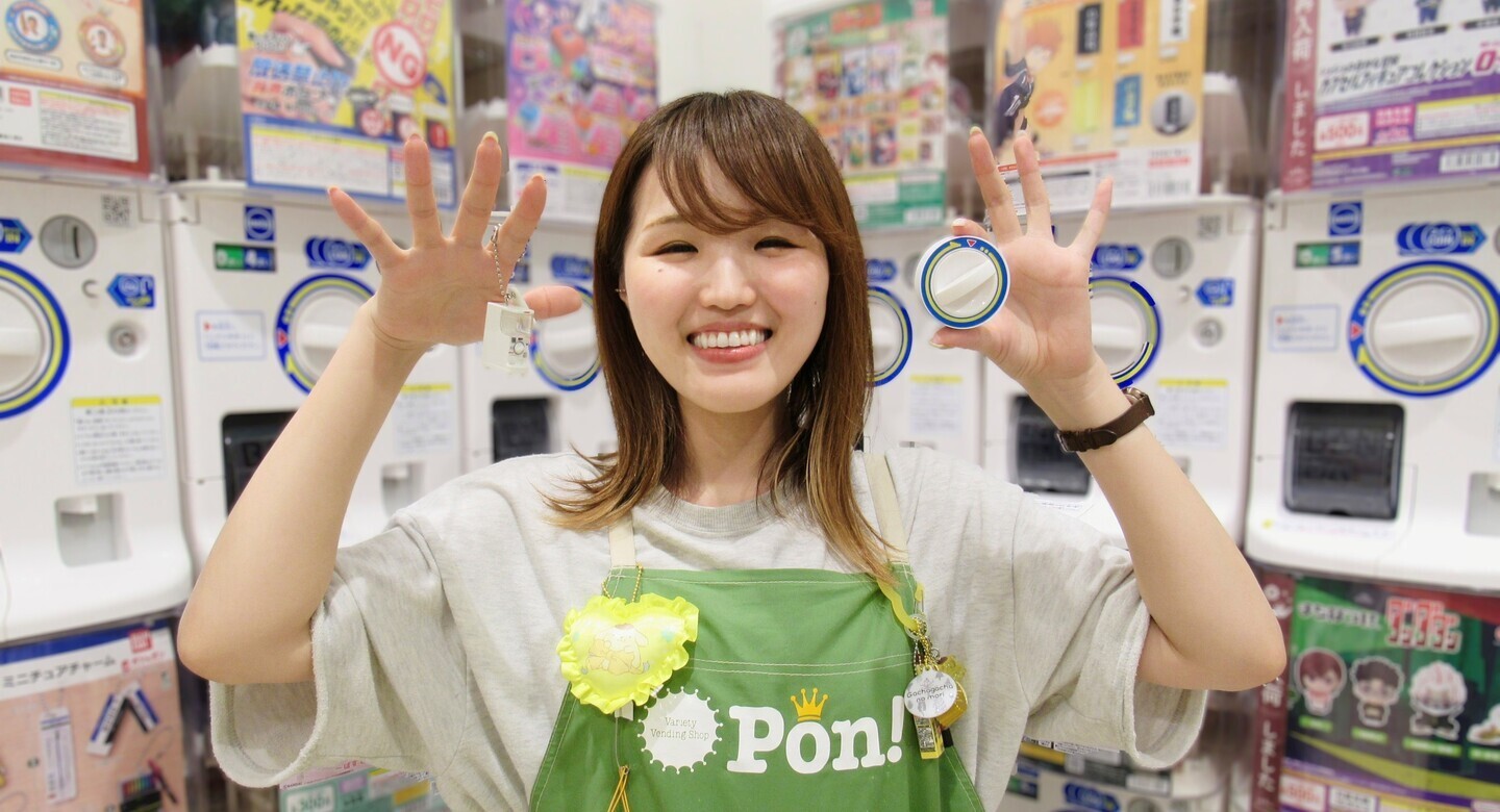 Pon!のエプロンを着けたスタッフとカプセルトイマシン