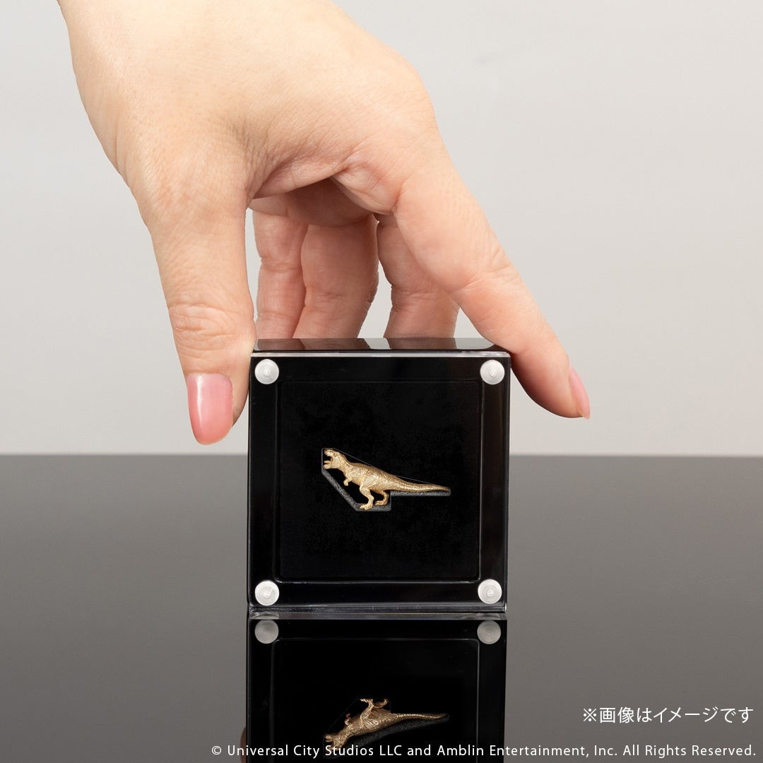 手で持ったケース入りのT.REX ミニフィギュア K18イエローゴールド