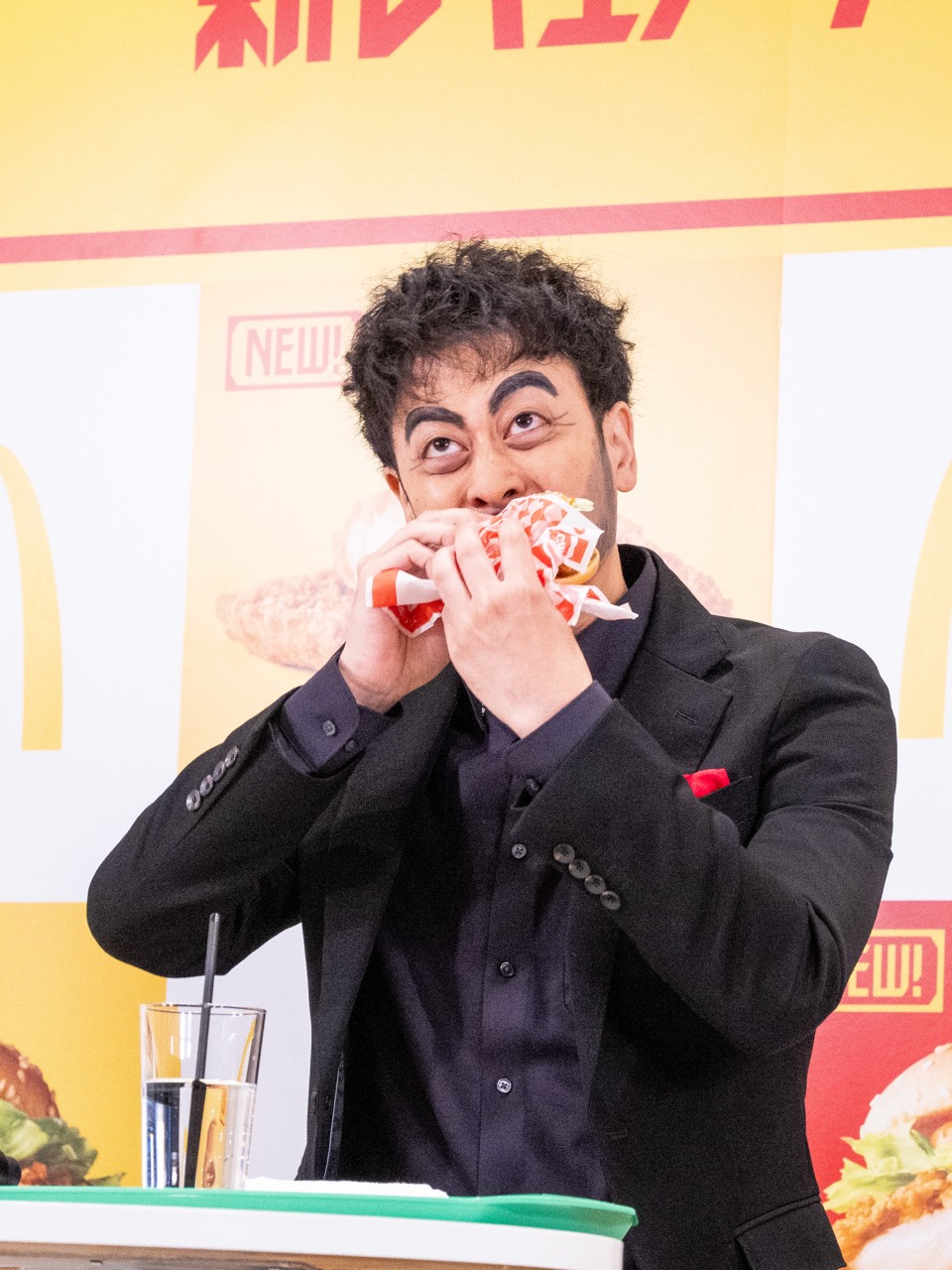 チキンバーガーを試食する都留拓也さん